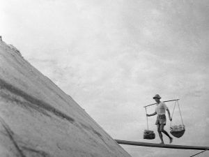 Time and Tide by Foo Tee Jun - Worker balances supplies, c.1960s