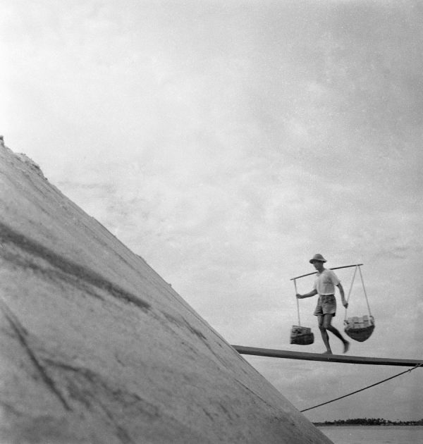 Time and Tide by Foo Tee Jun - Worker balances supplies, c.1960s