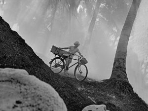 Time and Tide by Foo Tee Jun - Man pushes bicycle at Mata Ikan, c.1960s