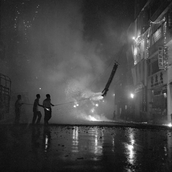 Time and Tide by Foo Tee Jun - Setting off firecrackers along Hong Kong Street, c. 1960s