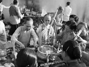 Time and Tide by Foo Tee Jun - Women light joss sticks at Yuen Hai Ching temple, c. 1960s