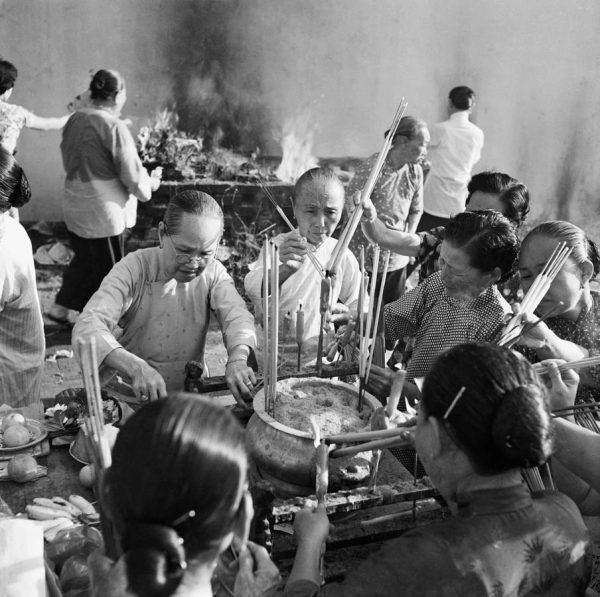 Time and Tide by Foo Tee Jun - Women light joss sticks at Yuen Hai Ching temple, c. 1960s