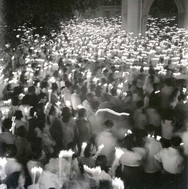 Time and Tide by Foo Tee Jun - Devotees attending night mass on Victoria Street, c. 1960s
