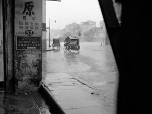 Time and Tide by Foo Tee Jun - Scene of rainy day along Chulia Street, c. 1960s