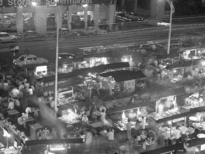 Time and Tide by Foo Tee Jun - Street hawkers along Orchard Road at dusk, c. 1970s