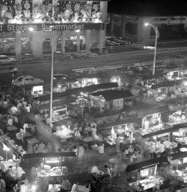 Time and Tide by Foo Tee Jun - Street hawkers along Orchard Road at dusk, c. 1970s
