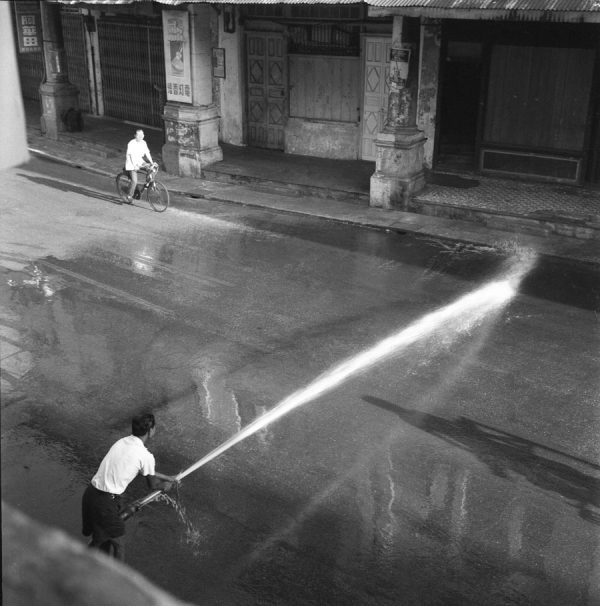 Time and Tide by Foo Tee Jun - Street washing on Chulia Street, c. 1960s
