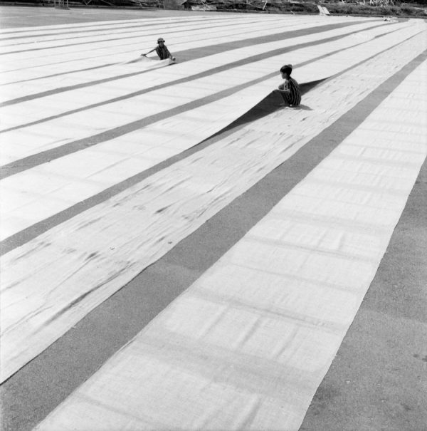 Time and Tide by Foo Tee Jun - Boys laying out cloth to dry at former Kallang Airport, c. 1960s