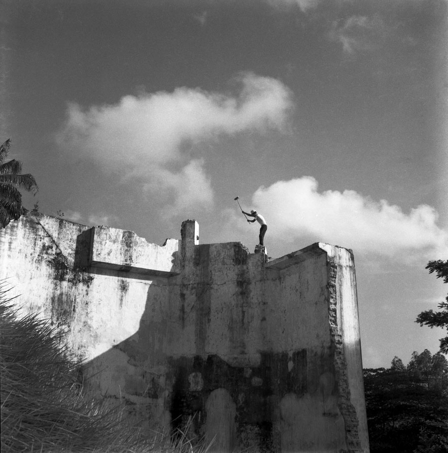 Time and Tide by Foo Tee Jun - Worker tears down walls of prison complex, 1963