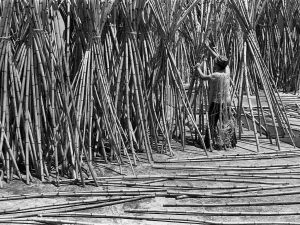 Time and Tide by Foo Tee Jun - Worker suns rattan after washing them in Kim Keat, c. 1970s