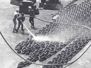 Time and Tide by Foo Tee Jun - Workers hose down ship chains at shipyard, c. 1960s