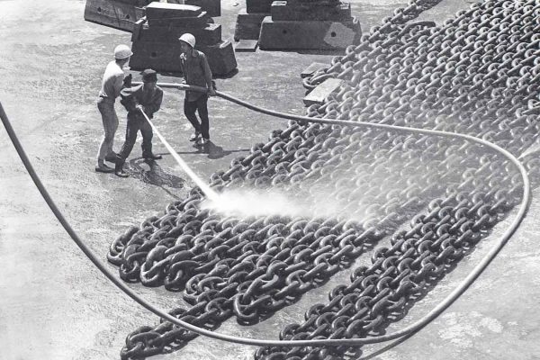 Time and Tide by Foo Tee Jun - Workers hose down ship chains at shipyard, c. 1960s