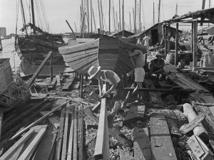 Time and Tide by Foo Tee Jun - Workers construct boats at shipyard along Kallang River, c. 1960s