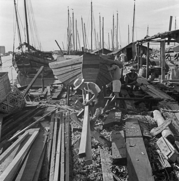 Time and Tide by Foo Tee Jun - Workers construct boats at shipyard along Kallang River, c. 1960s
