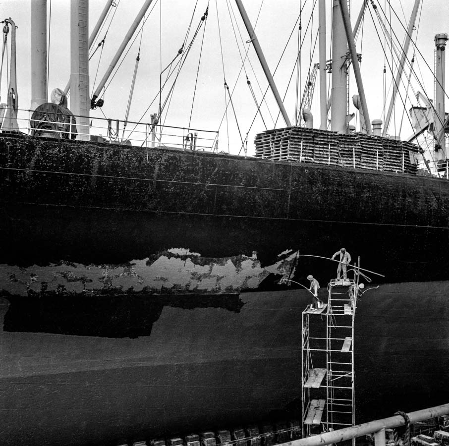 Time and Tide by Foo Tee Jun - Workers atop a scaffold paint a ship at Jurong shipyard, 1973