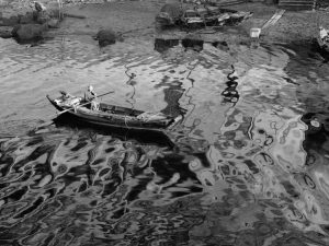 Time and Tide by Foo Tee Jun - Boatman paddles boat on Singapore River, c. 1960s