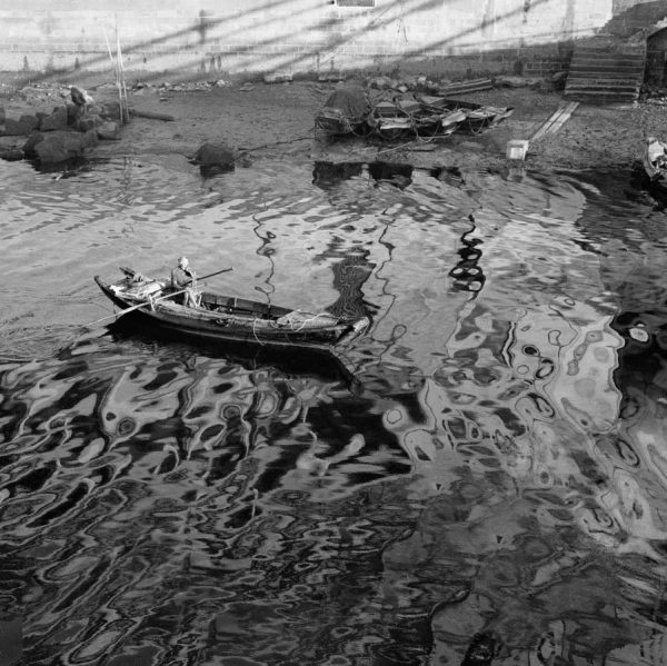 Time and Tide by Foo Tee Jun - Boatman paddles boat on Singapore River, c. 1960s