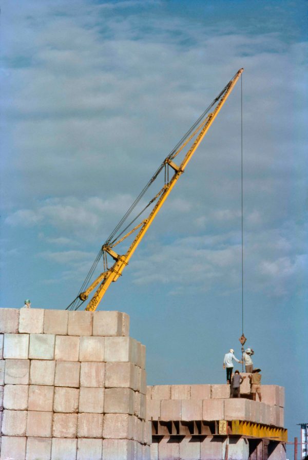 Time and Tide by Foo Tee Jun - Workers unloading cement blocks for piling, c. 1970s