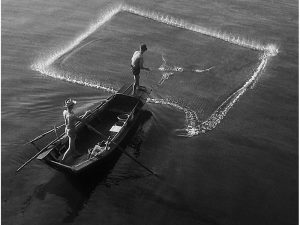 Passing Time by Lui Hock Seng - Fisherman casting net, Merdeka Bridge, c. 1960s – 1970s