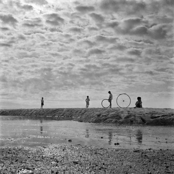 Passing Time by Lui Hock Seng - Kids playing with bicycle wheel rims, Bedok Beach, c. 1960s – 1970s